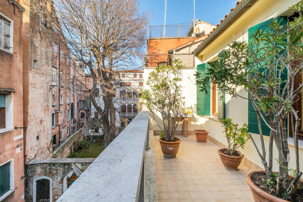an alley with potted plants and buildings at Del Remer Apartment - 5mins from San Marco sq in Venice