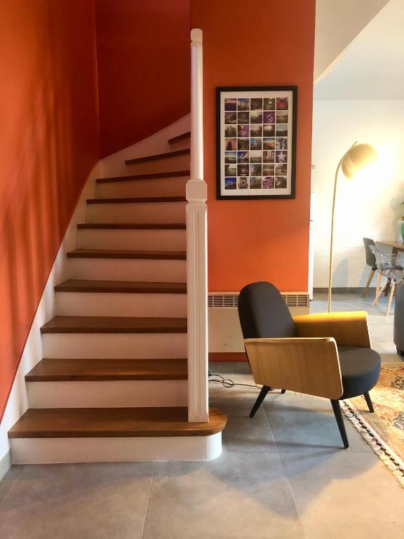 un escalier dans un salon avec une chaise dans l'établissement Le Pressoir de la Gervaiserie - 300m de la plage, à Réville