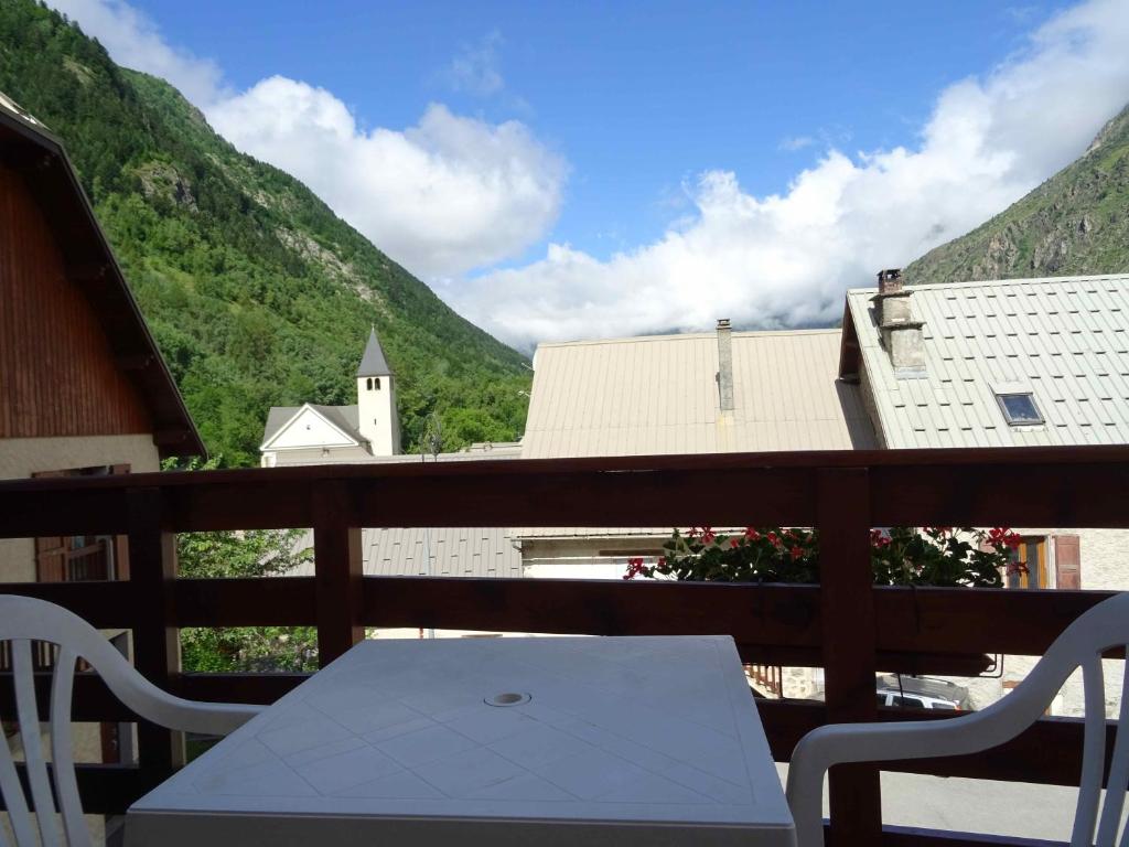 uma mesa branca e cadeiras numa varanda com montanhas em Les Oulles em La Chapelle-en-Valgodemard