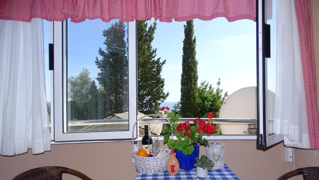 una mesa con un jarrón de flores delante de una ventana en Apartment Alexander, en Bečići