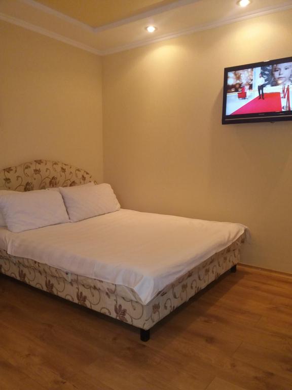 ポルタヴァにあるApartment na Zenkovskoiの壁にテレビが備わるドミトリールームのベッド1台分です。