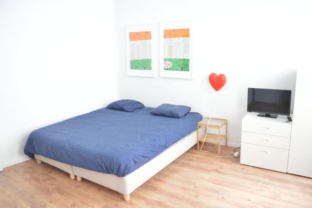 a bedroom with a bed and a flat screen tv at Awesome Studio in Marolles in Brussels