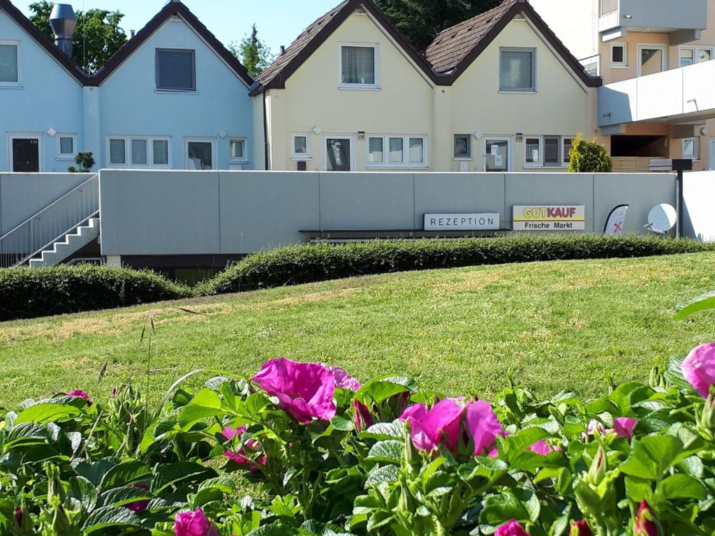 a group of houses with pink flowers in the foreground at Ferienwohnung Yachthof Scheid in Scheid