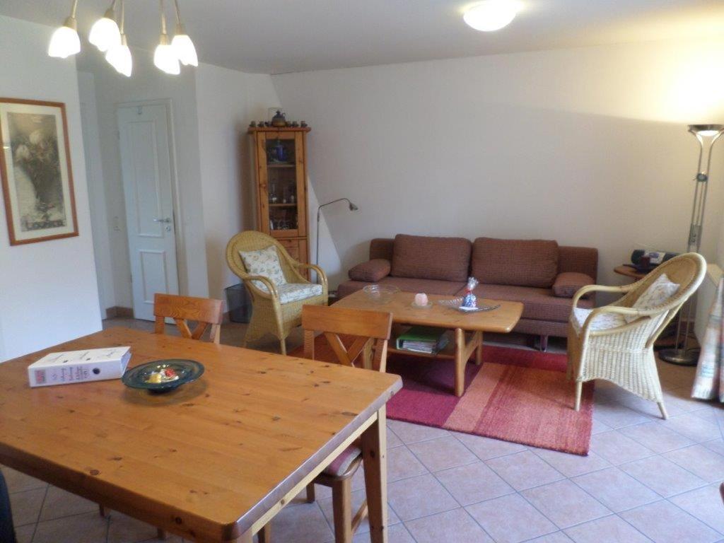 ein Wohnzimmer mit einem Sofa, einem Tisch und Stühlen in der Unterkunft Appartementhaus Gegenkolonnaden in Kühlungsborn