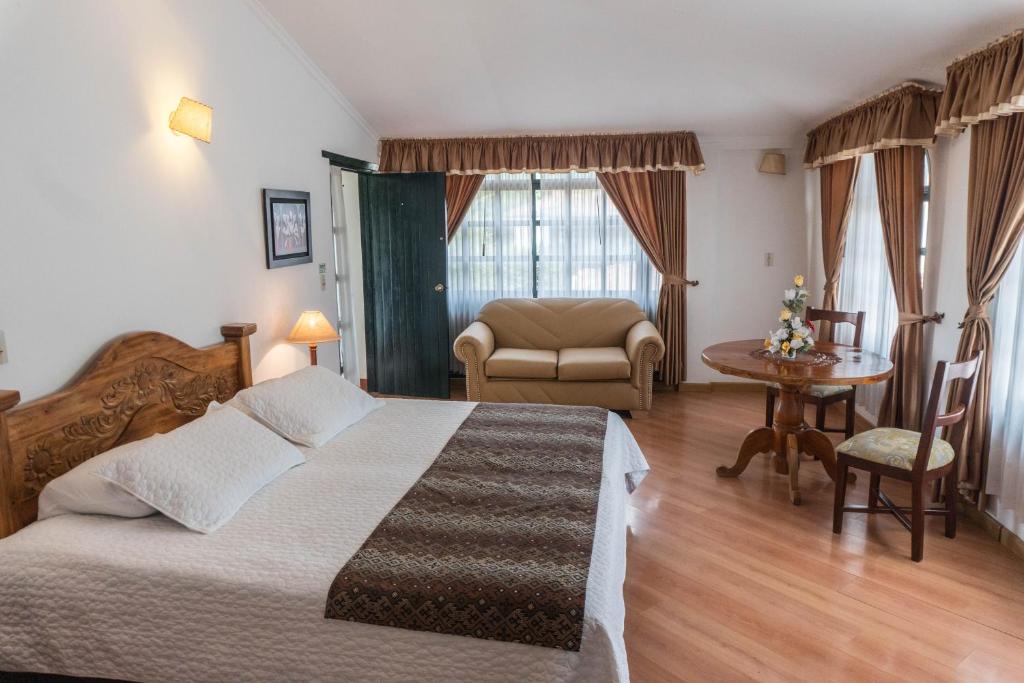 um quarto com uma cama, uma mesa e uma cadeira em Hotel Andres Venero em Villa de Leyva