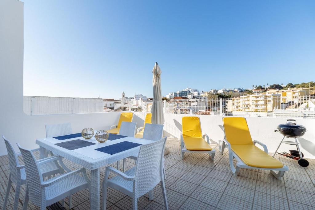 a patio with a table and chairs on a roof at Top renoviertes Apartment mit großer Terrasse in Albufeira