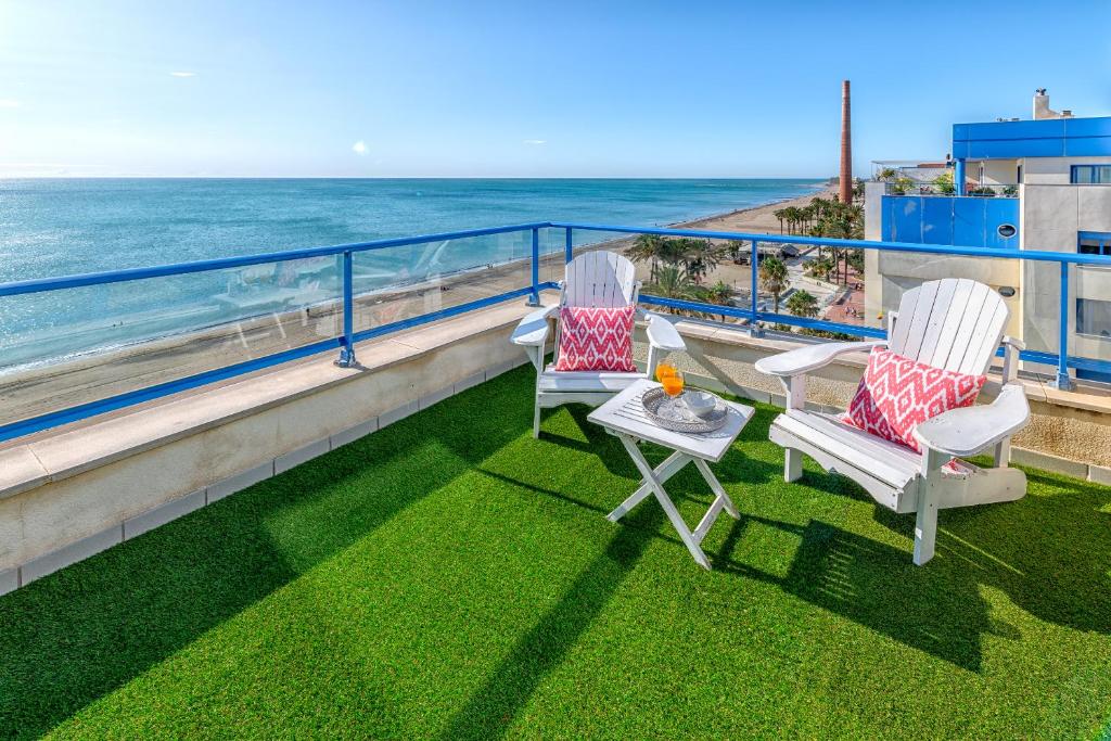 two chairs and a table on a balcony overlooking the ocean at iloftmalaga Ático Pacífico 19 B in Málaga