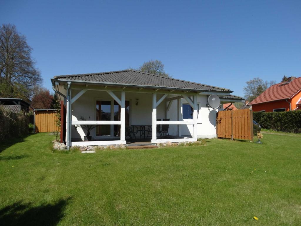 a small white house with a green yard at Ruegen_Fewo 279_1 in Putbus