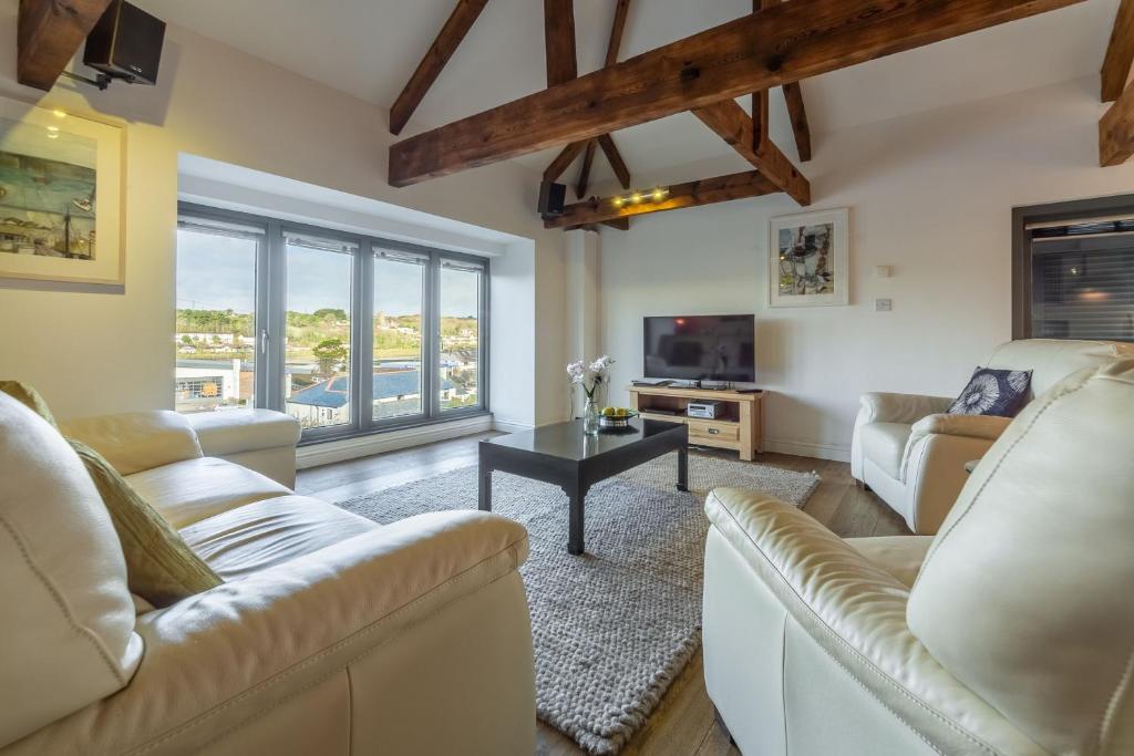 a living room with two couches and a tv at Copperhouse View in Hayle