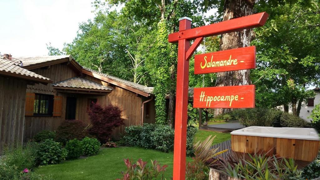 a red street sign in front of a house at Salamandre et Hippocampe in Lanton