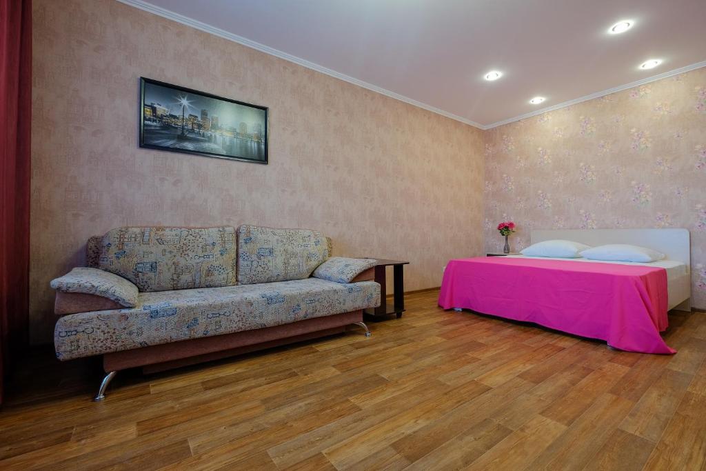 a living room with a couch and a bed at ОК! Советская, 60 №1 in Tomsk