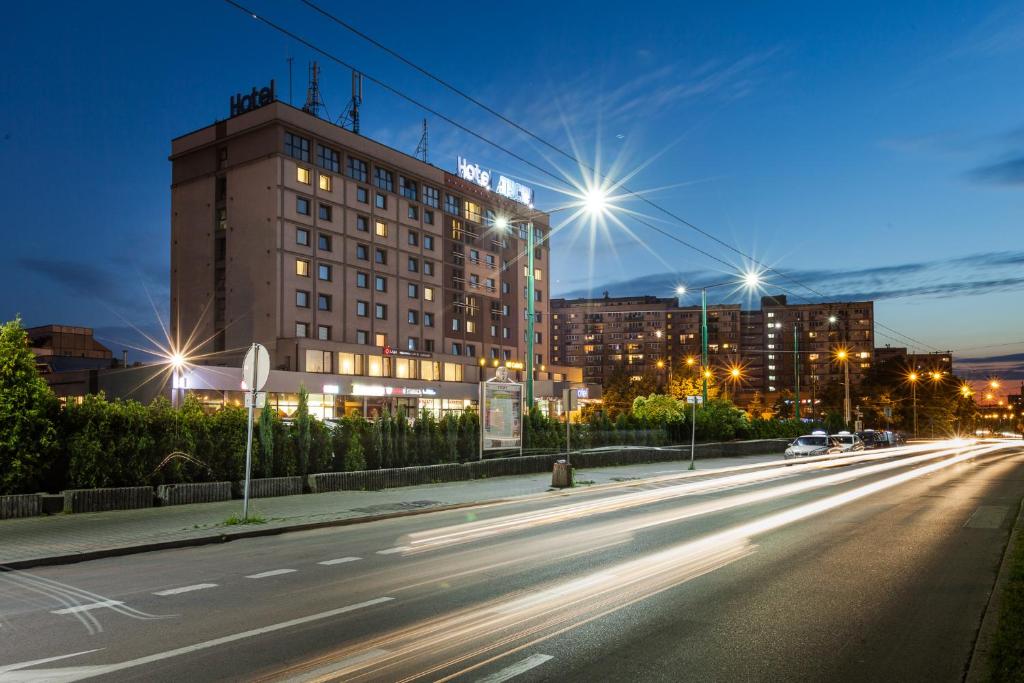 a city street at night with buildings and street lights at Hotel Tychy in Tychy