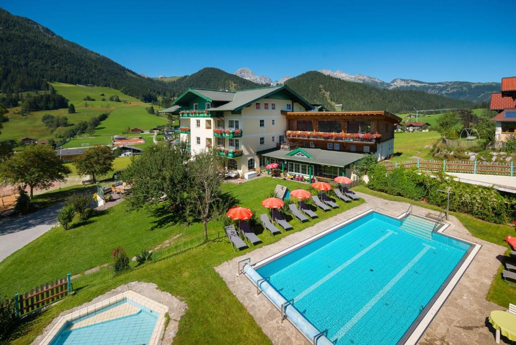 an aerial view of a resort with a swimming pool at Wohlfühlresort und Feriengut Martinerhof in Sankt Martin am Tennengebirge