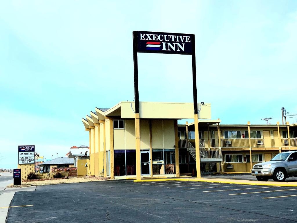 un bâtiment avec un panneau indiquant l'auberge exécutive dans l'établissement Executive Inn Dodge City, KS, à Dodge City