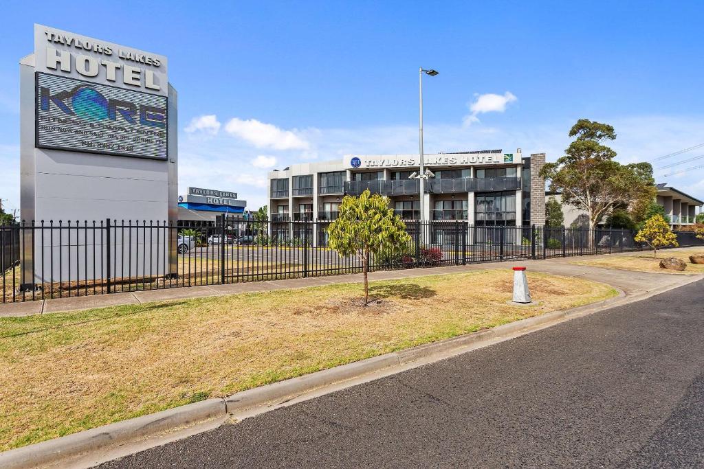 an empty street with a building and a fence at Quality Hotel Taylors Lakes in Taylors Lakes