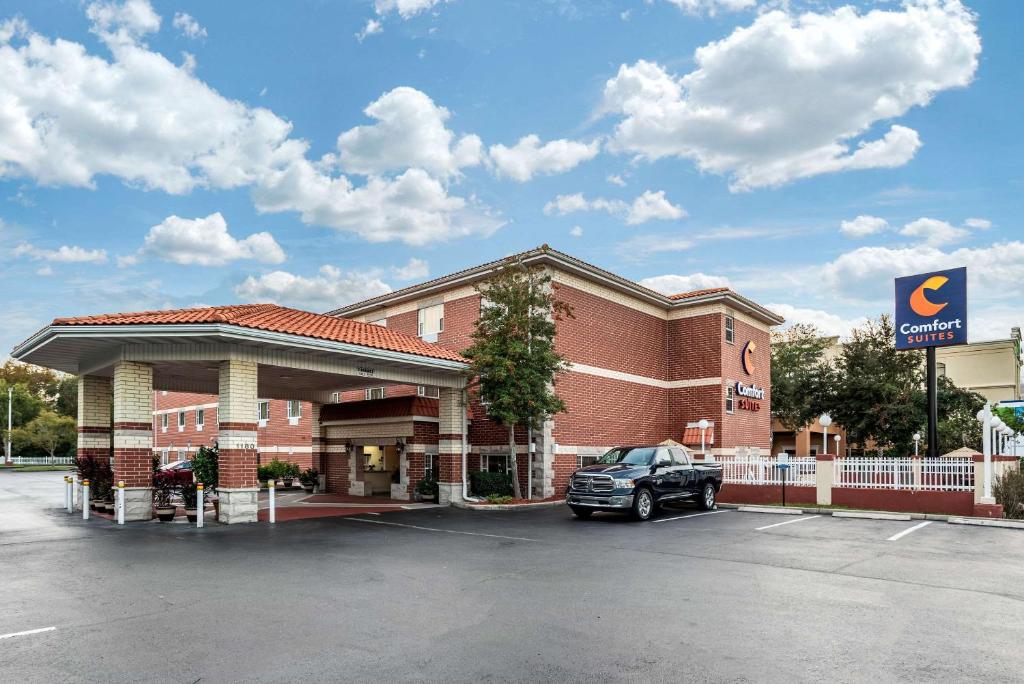 a hotel with a car parked in front of it at Comfort Suites Airport in Jacksonville