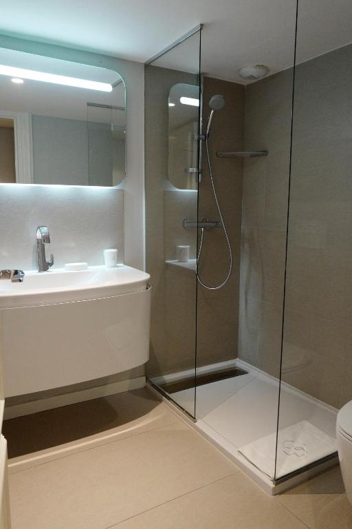 a bathroom with a shower and a sink at Clarance Hotel Lille in Lille