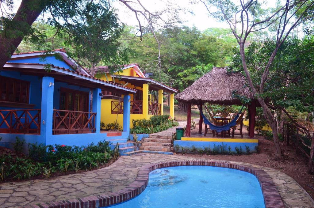 a villa with a swimming pool in front of a house at Los Volcanes, Playa el Coco in Escameca