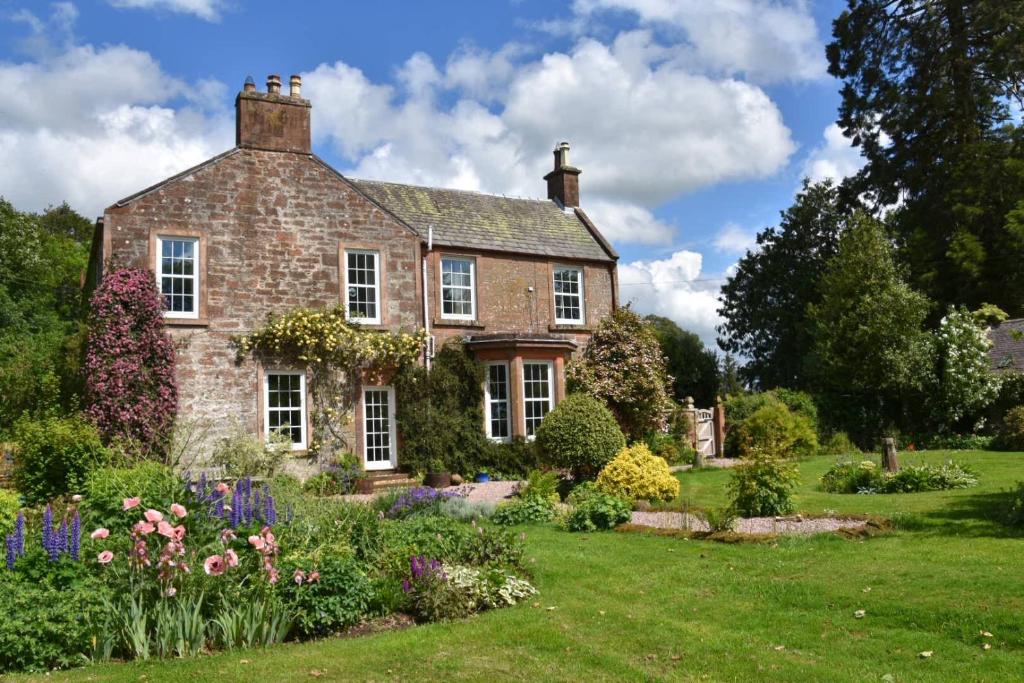 an old brick house with a garden in front of it at Applegarth House in Lockerbie