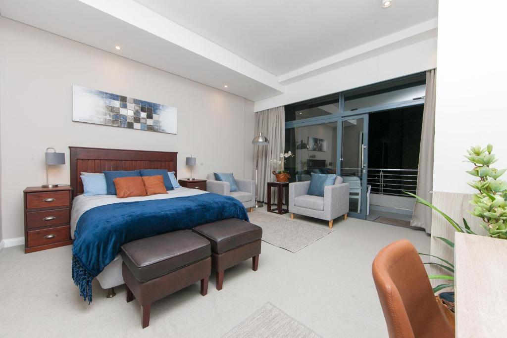a bedroom with a bed with a blue bedspread at Ace Location walk to Sun Arena & Menlyn CBD WiFi Self Catering in Pretoria