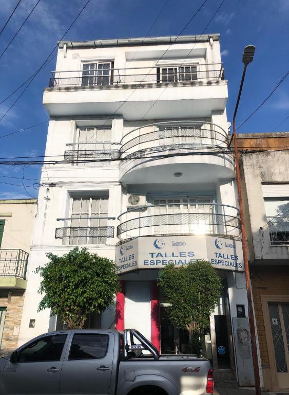 a truck parked in front of a white building at Le Parc in Gualeguaychú