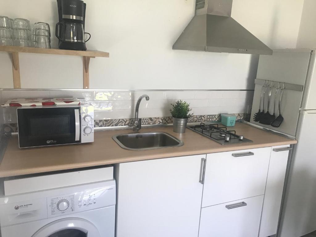 a kitchen with a sink and a microwave at La Casita de Laura in Bolonia