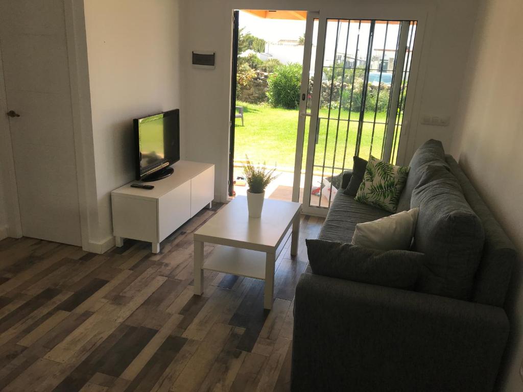 a living room with a couch and a tv and a table at La Casita de Laura in Bolonia