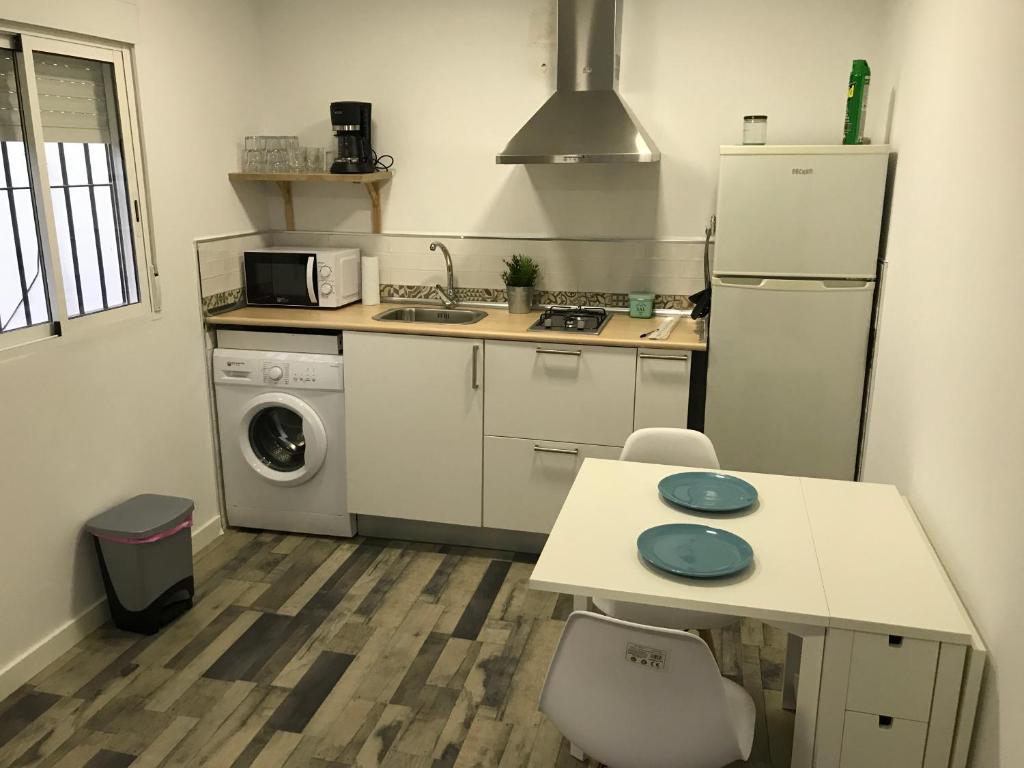 a kitchen with a refrigerator and a table and a sink at La Casita de Laura in Bolonia