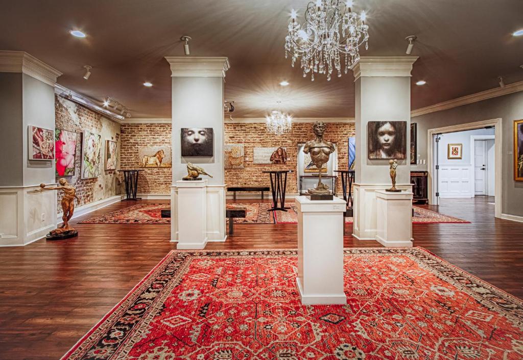 a large room with a red rug and art on the walls at The Vendue, Downtown Art Hotel in Charleston