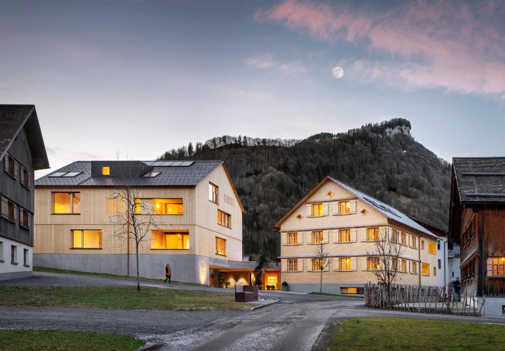 a large house in a village with a mountain at Tempel 74 Apartments in Mellau