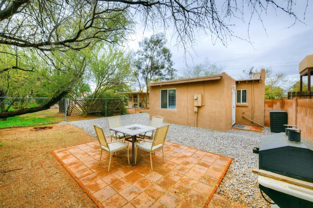 a backyard with a table and chairs and a house at Orchard Bungalow in Tucson