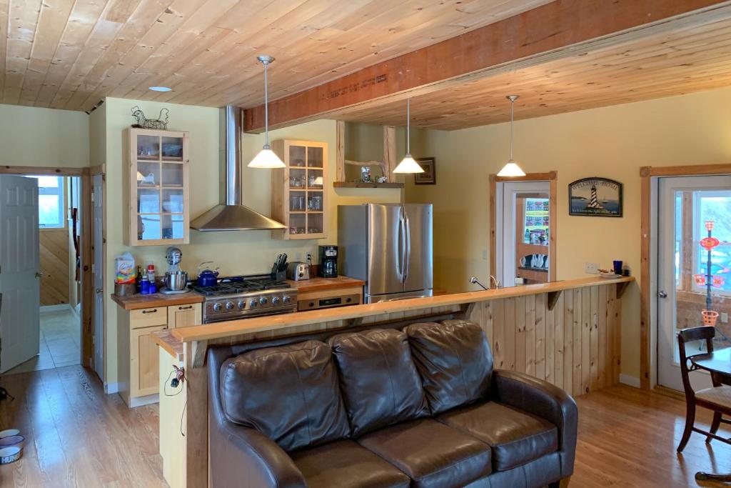 ein Wohnzimmer mit einem Ledersofa in der Küche in der Unterkunft Island's Escape in North Hero
