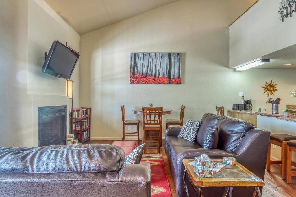 a living room with two leather couches and a tv at Aspen Loft in Pagosa Springs