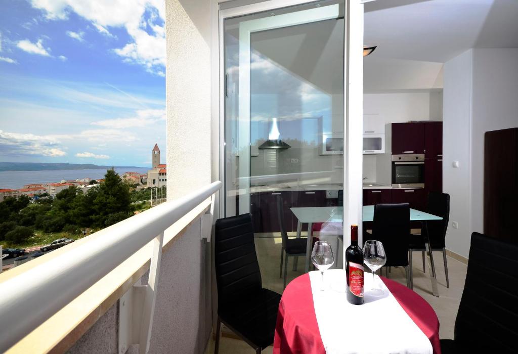 a balcony with a table with wine glasses on it at Apartment West in Makarska