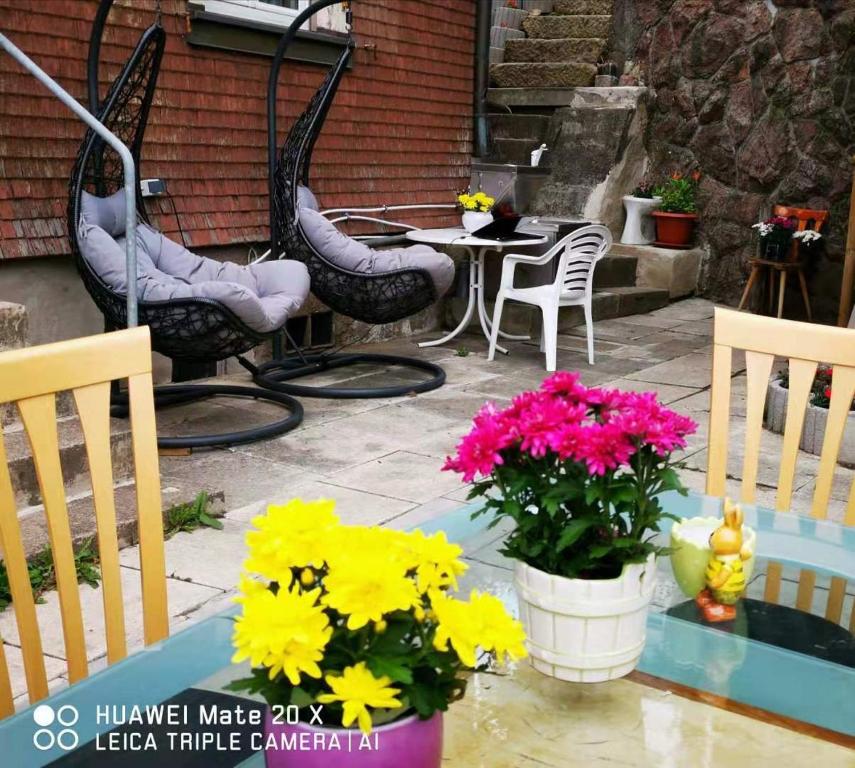 a patio with chairs and flowers on a table at Rosen Garten Haus in Titisee-Neustadt