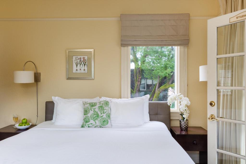 a bedroom with a large white bed and a window at Healdsburg Inn on the Plaza, A Four Sisters Inn in Healdsburg