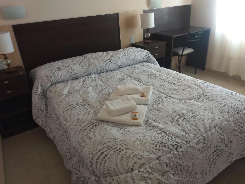 Un dormitorio con una cama con dos toallas encima. en hotel andino, en La Rioja
