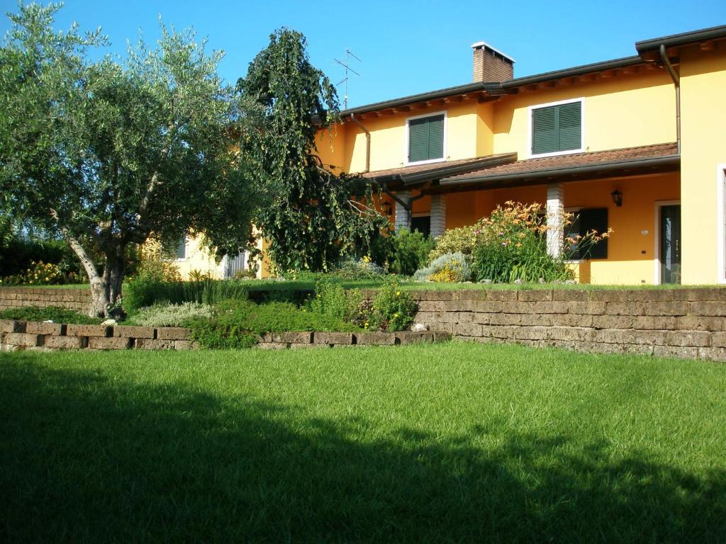 une cour devant une maison avec un arbre dans l'établissement Bed and Breakfast il Faggio, à Povegliano Veronese