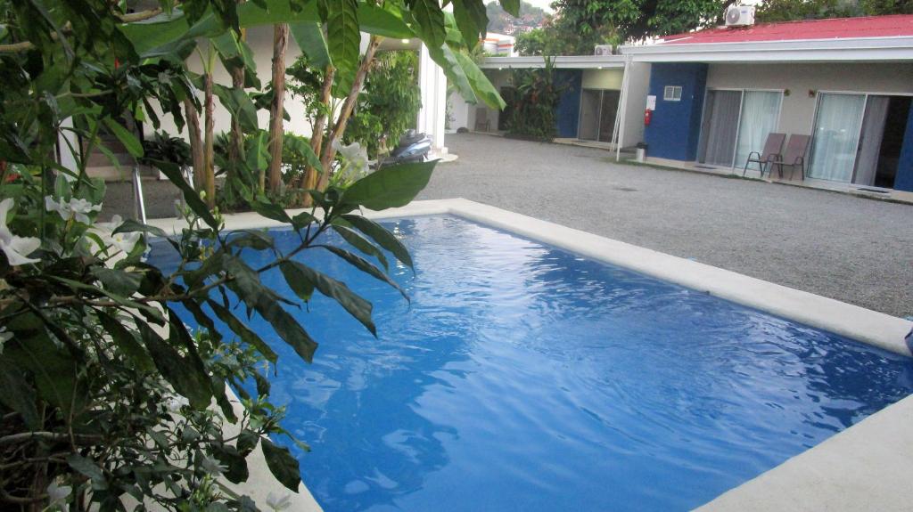 a blue swimming pool in front of a house at Sueño Tranquilo in Quepos