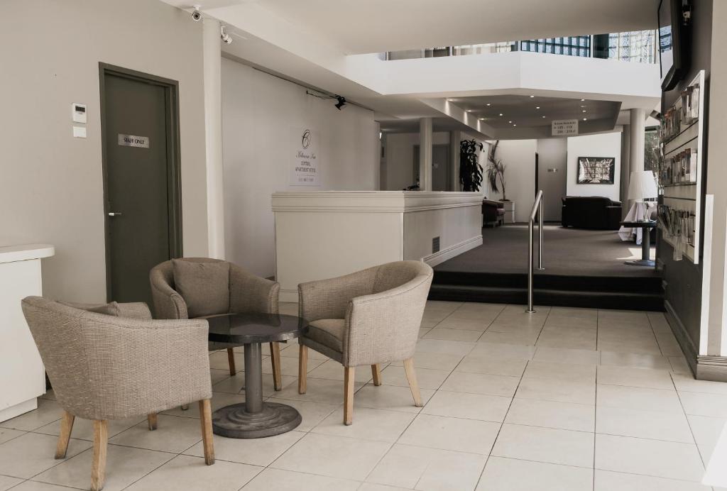 um quarto com uma mesa e cadeiras e um corredor em Melbourne Kew Central Apartments Official em Melbourne