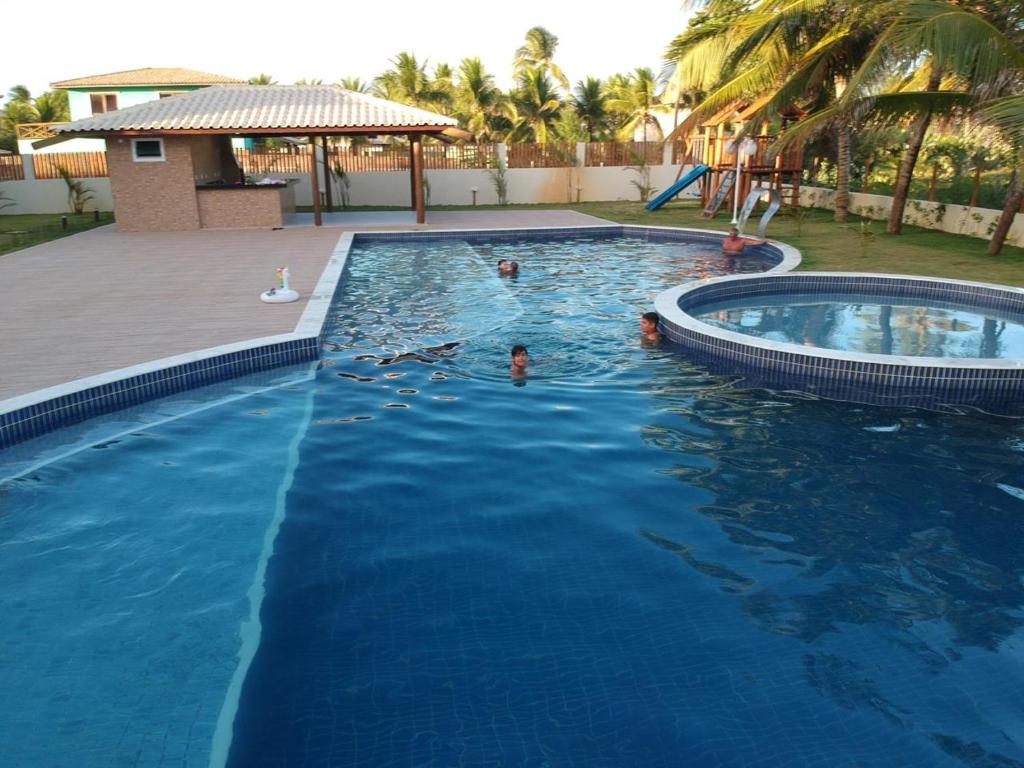 un grupo de personas nadando en una piscina en Residencial Itacimirim Sumer Ville, en Camaçari