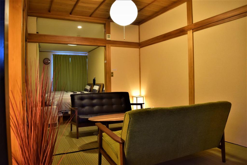 a room with a chair and a table and a bed at Hidamari in Takayama