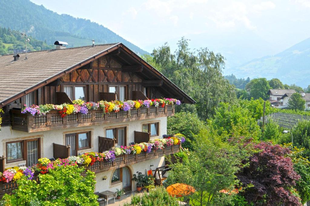 dom z kwiatami na balkonach w obiekcie Garni Pöhl w mieście Tirolo