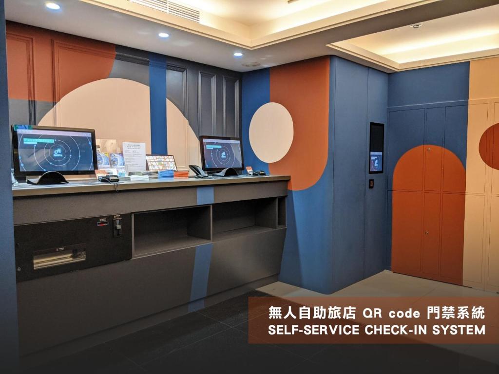 eine Lobby mit einem Schreibtisch mit zwei Computern darauf in der Unterkunft Guide Hotel Taipei Xinyi in Taipeh