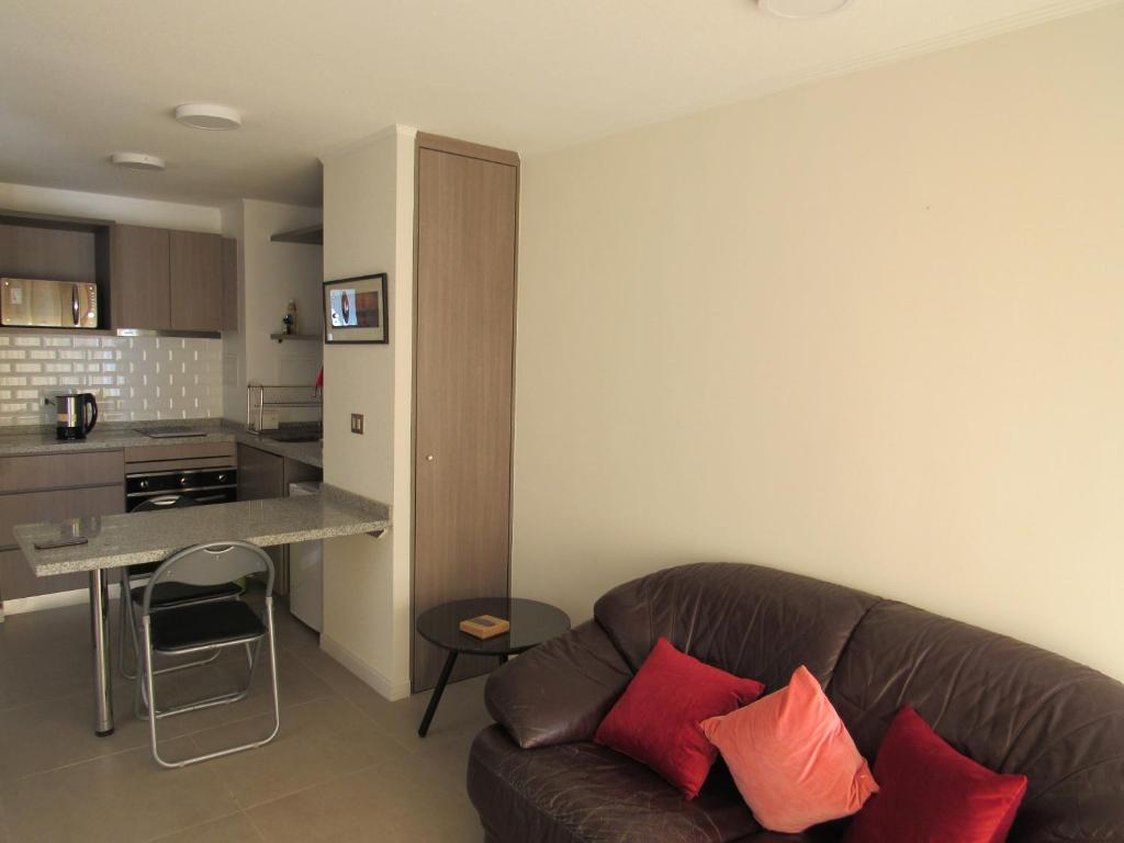 uma sala de estar com um sofá e uma cozinha em Birdhouse Apartment em Santiago