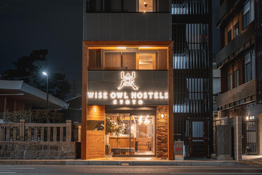 ein Gebäude mit einem Schild, auf dem die Frau im Hotel steht in der Unterkunft Wise Owl Hostels Kyoto in Kyoto