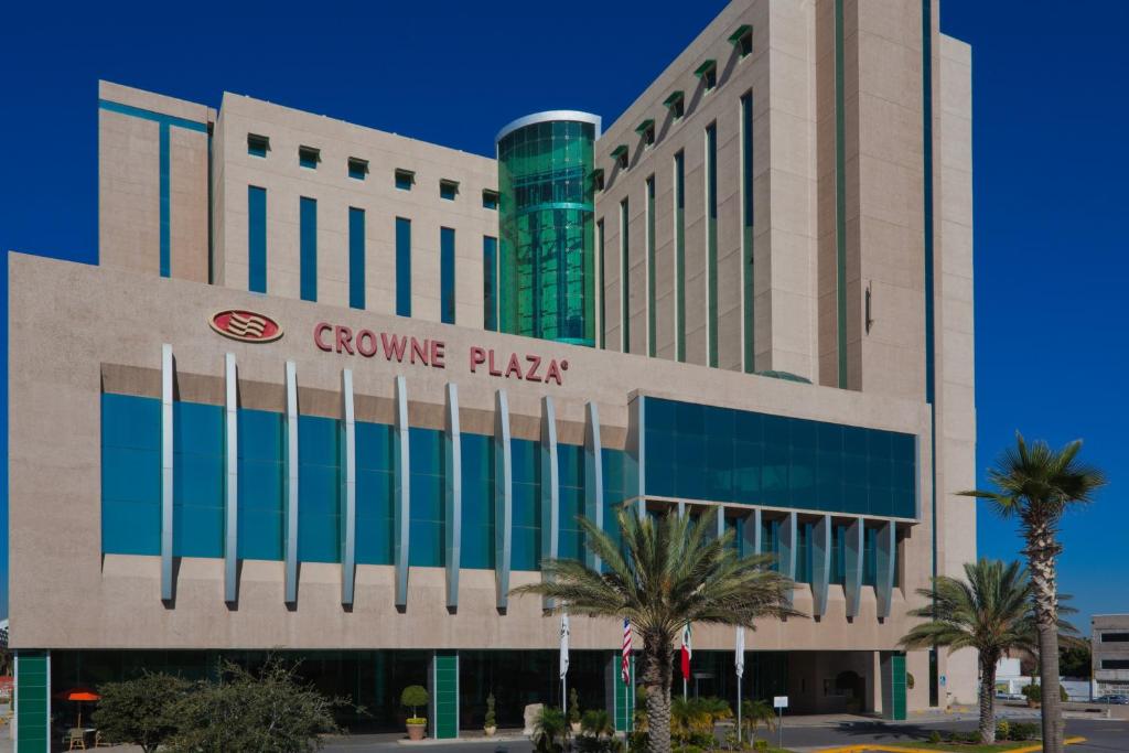 a building with a group of palm trees in front of it at Crowne Plaza Torreon by IHG in Torreón