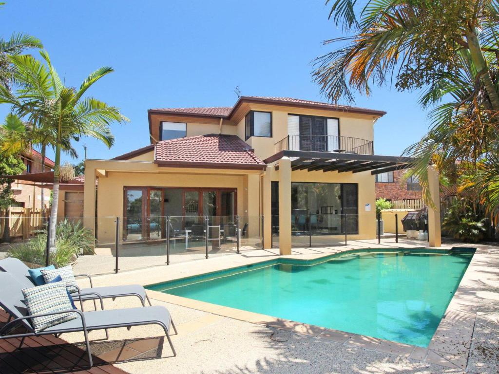 a house with a swimming pool in front of a house at Tarcoola 41 in Mooloolaba