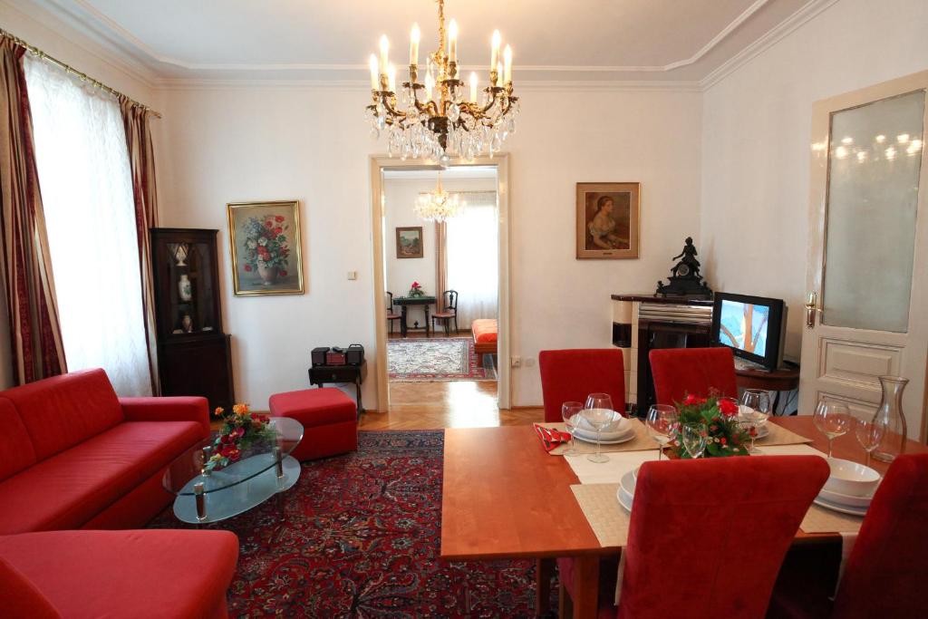 un soggiorno con tavolo e sedie rosse di Mozart Apartments - Rögergasse a Vienna