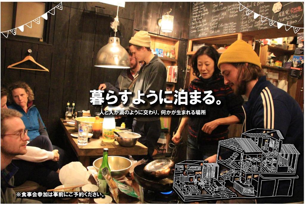 un groupe de personnes debout dans un restaurant dans l'établissement Guesthouse Yadocurly, à Onomichi